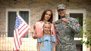 man in military uniform with family holding keys to home