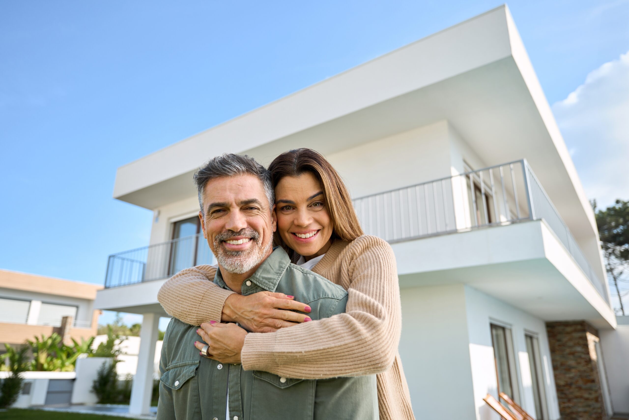 happy smiling couple in front of new property