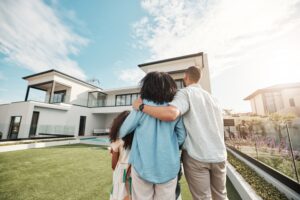 new home and family standing in yard looking