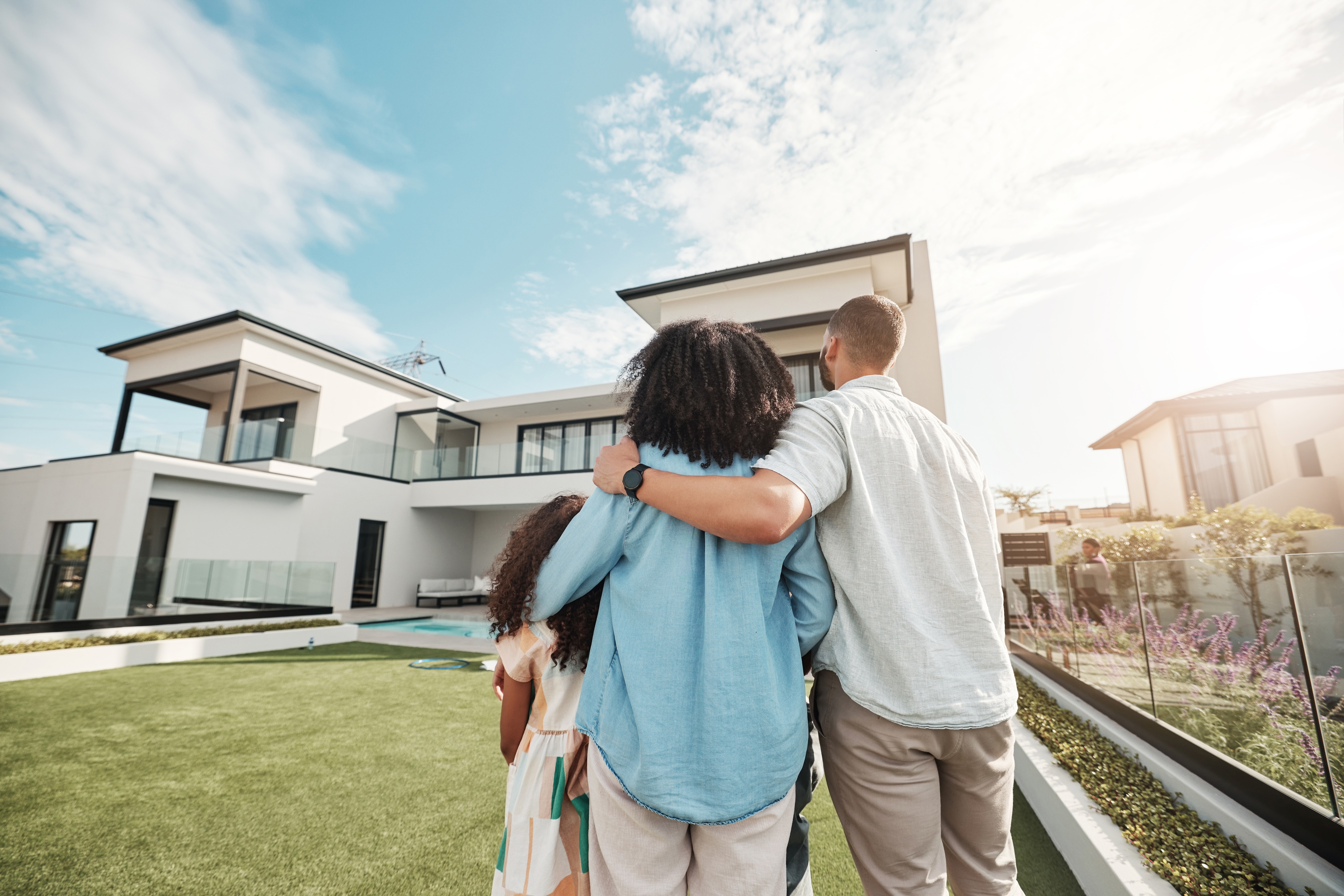 new home and family standing in yard looking