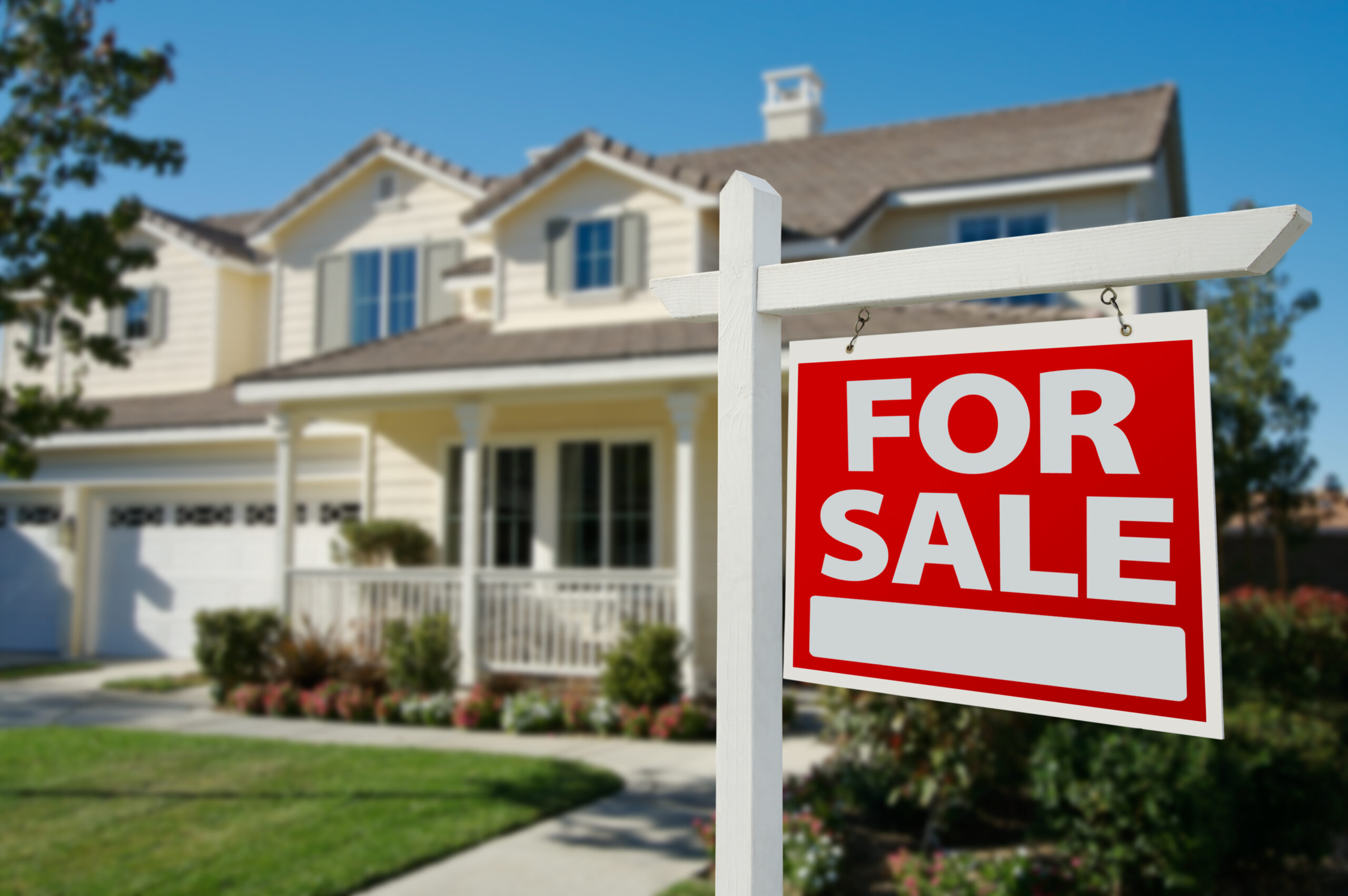 for sale sign with a home in the background