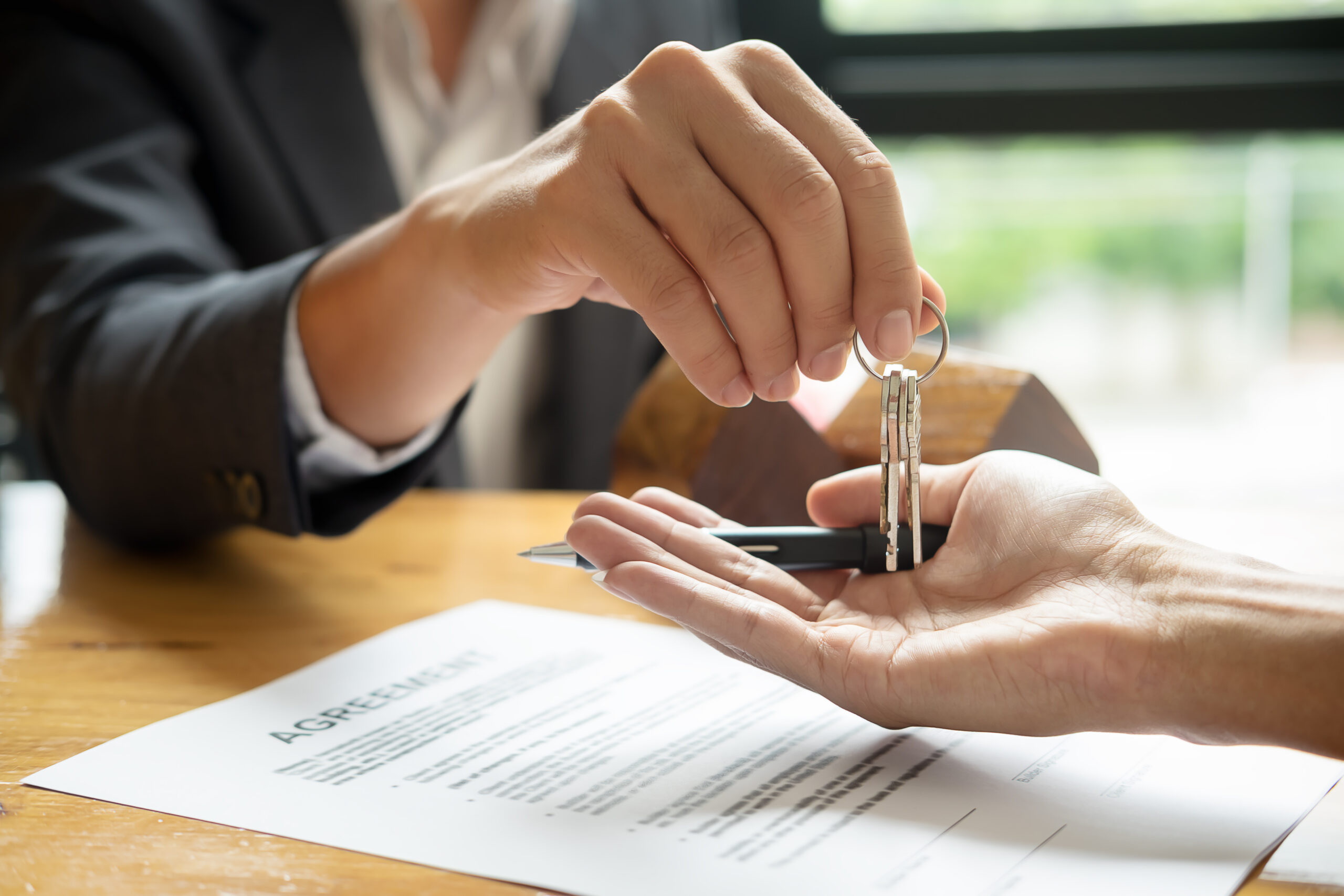 real estate agent holding house key to his client