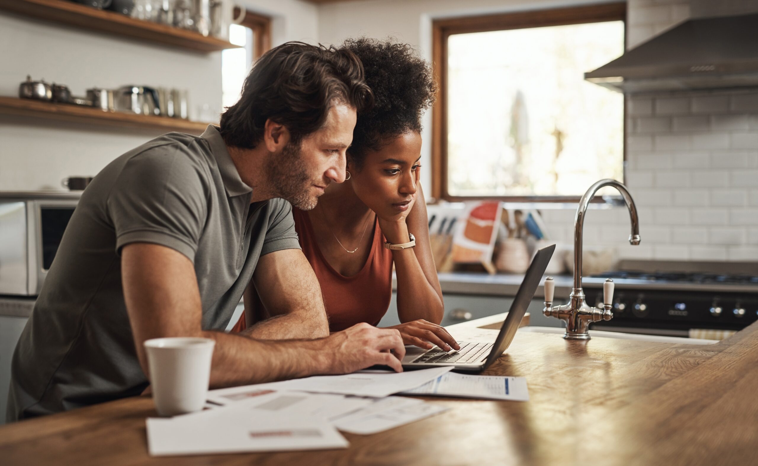 couple financial planning on a laptop in kitchen