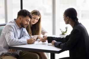 couple signing paper agreement during meeting