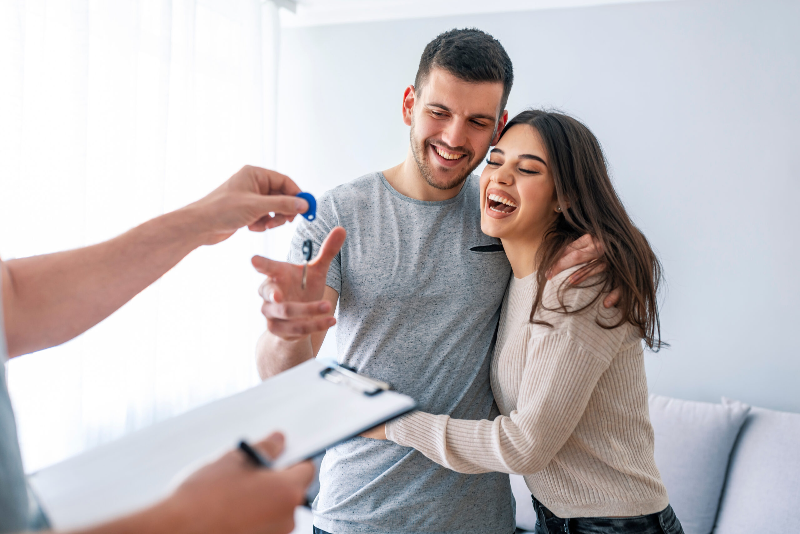 happy couple taking keys for new house
