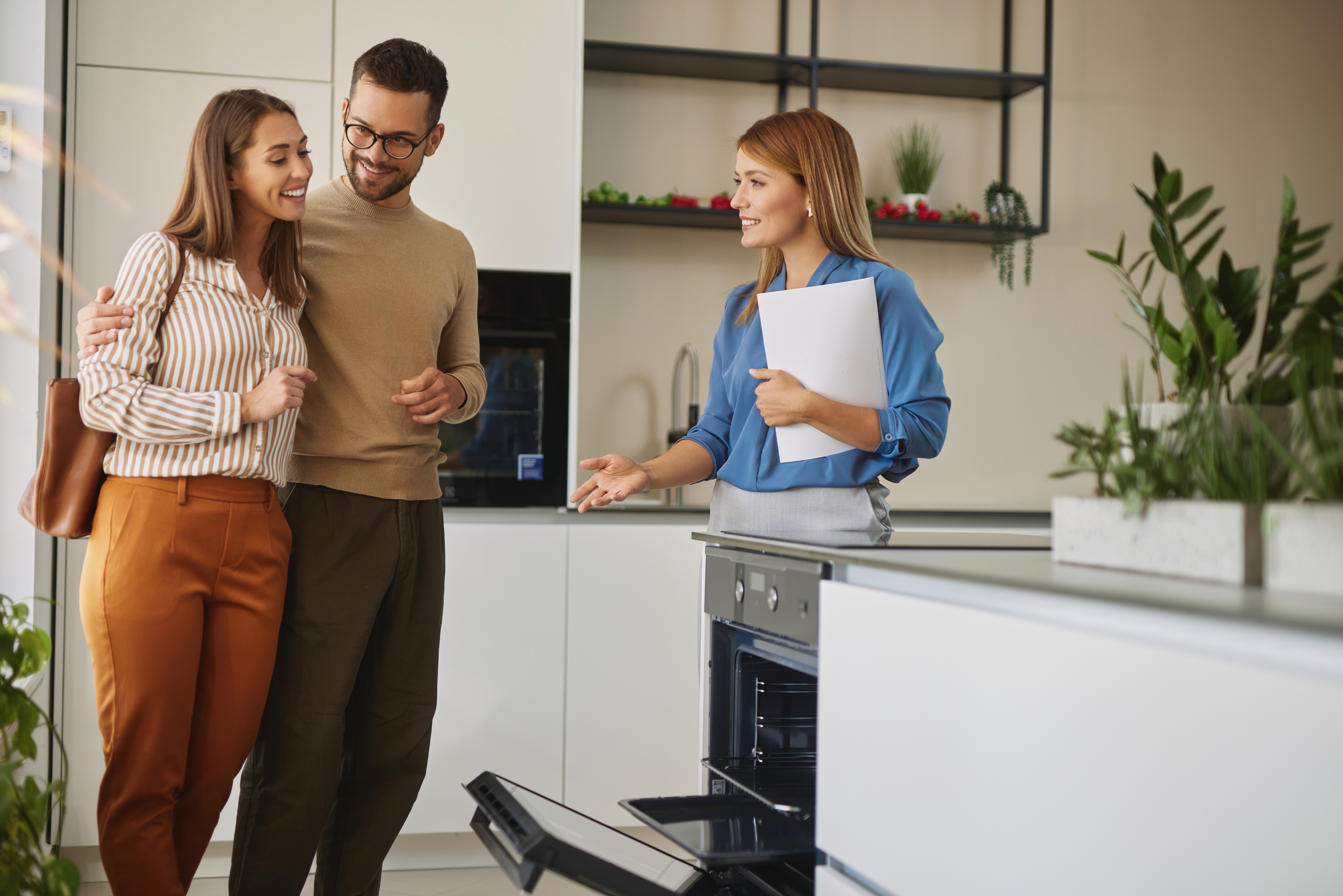 female taking young couple on tour of new home