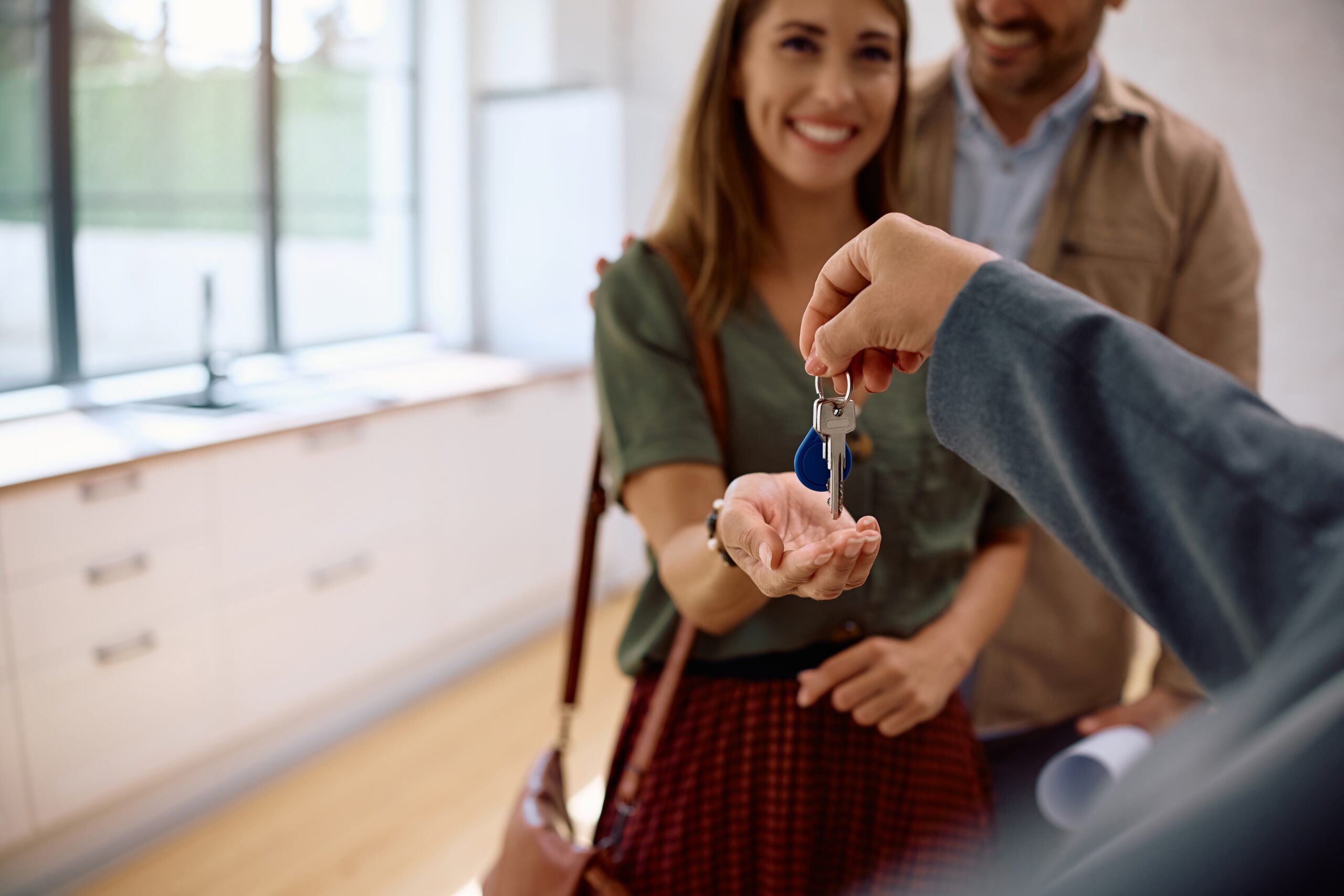 close up of real estate agent handing over keys to woman