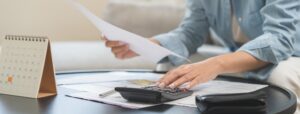 business woman reviewing documents and using calculator