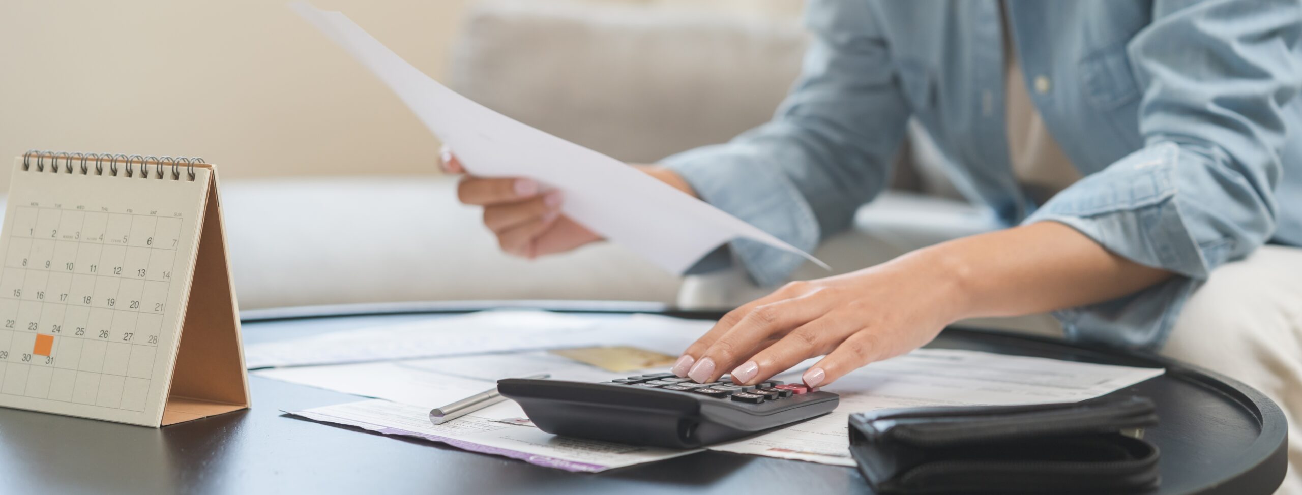 business woman reviewing documents and using calculator