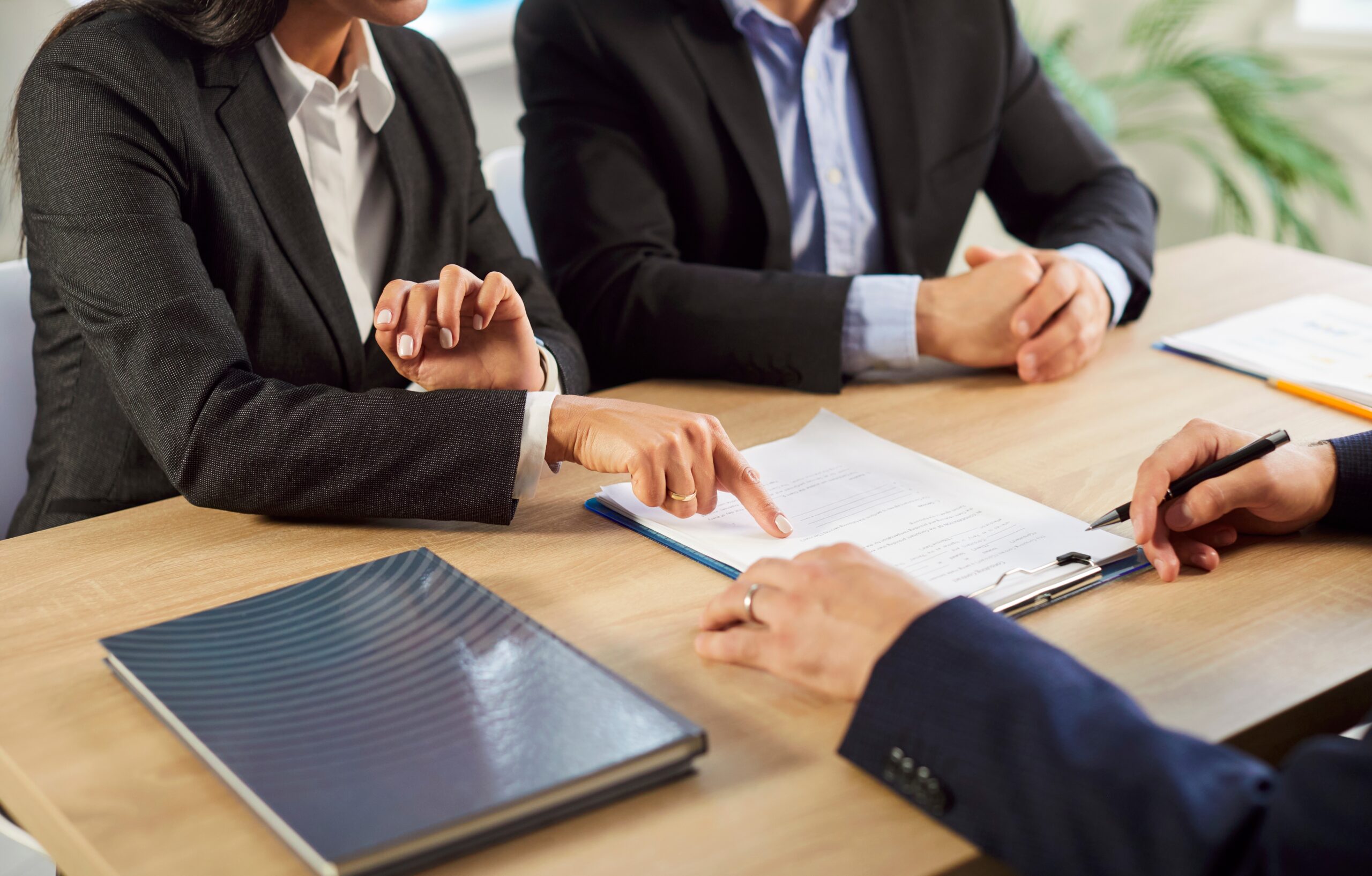 cropped shot of business clients meeting and fingers pointing at document