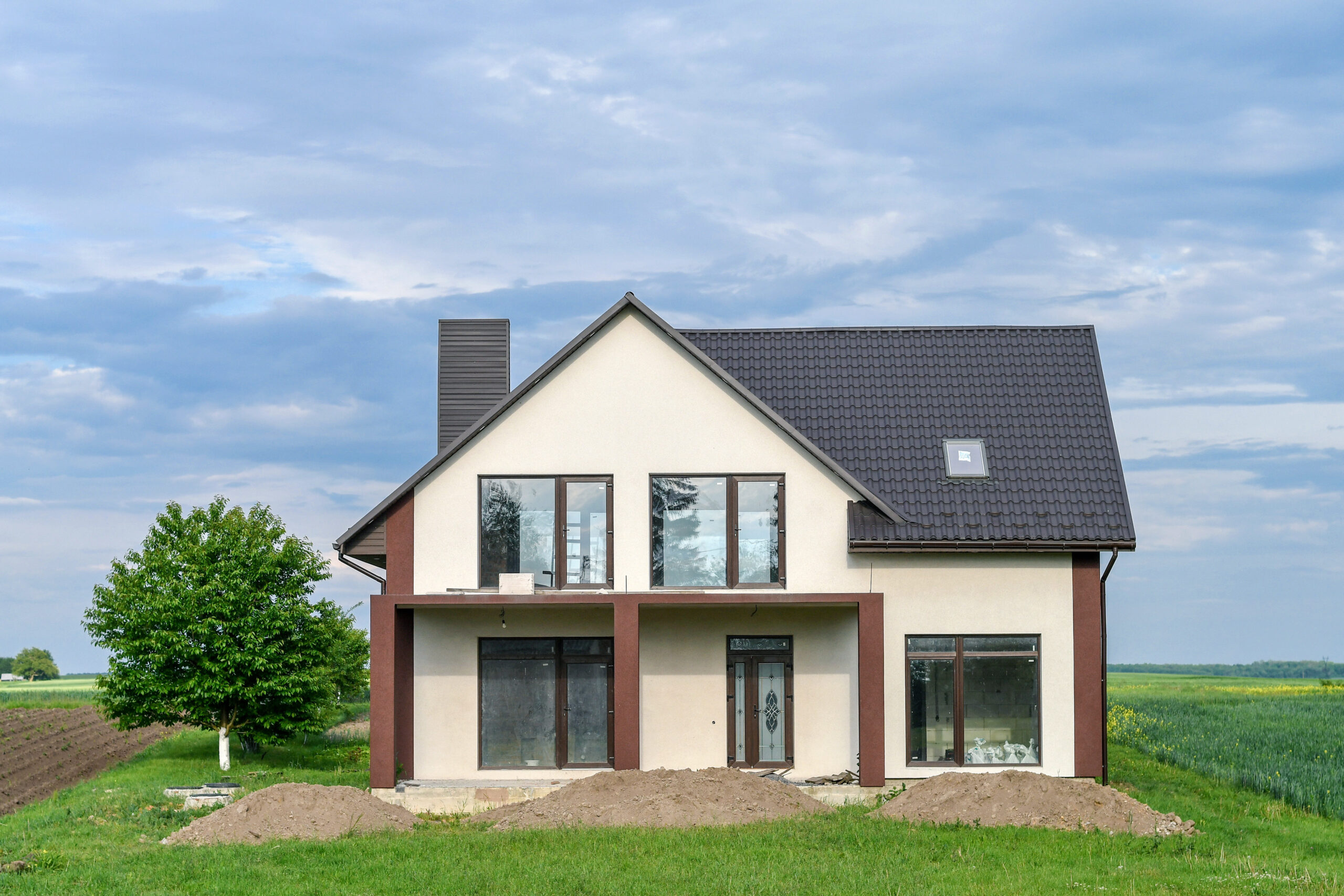 picture of a white home with a dark roof and yard
