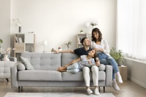 parents and child on couch in their home