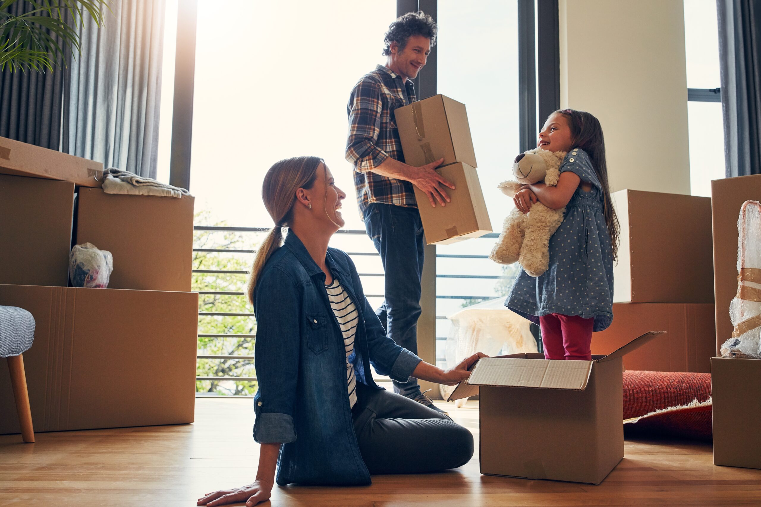 boxes and parents in new home with child