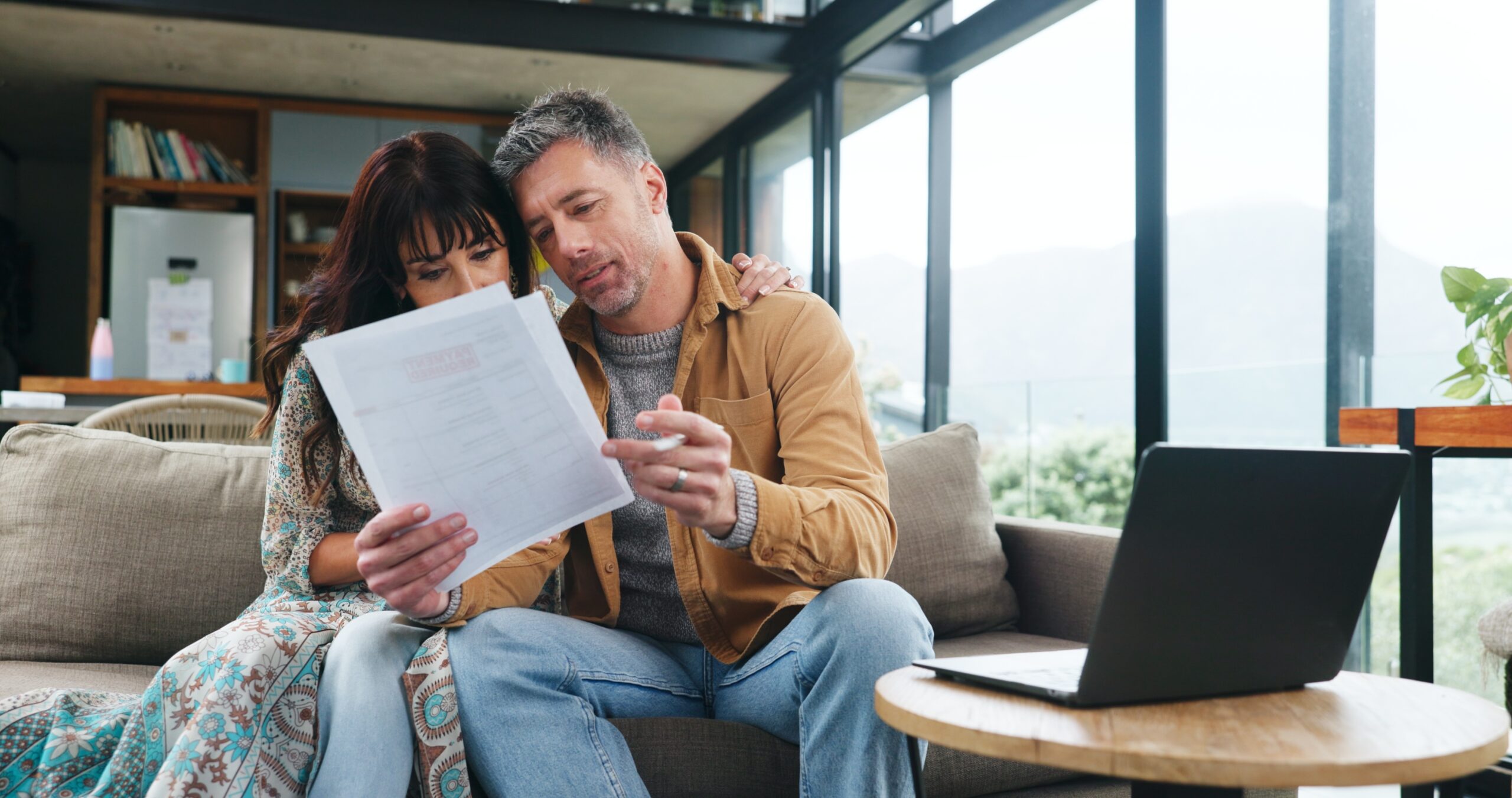 couple reading a document on the couch