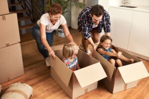 new house happy family playing in moving boxes